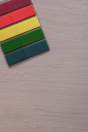 Colored bookmarks lie diagonally on the table. Stripe stickers. Flat lay. Red, yellow, green, blue. Copy space.の写真素材
