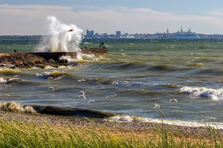 Landscape with a big burst of waves from the pier during the storm as a painted picture. Many...