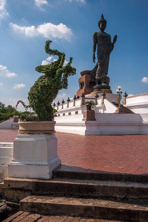 Perhaps the largest statue of a walking Buddha and an elephant standing on its hind legs in...