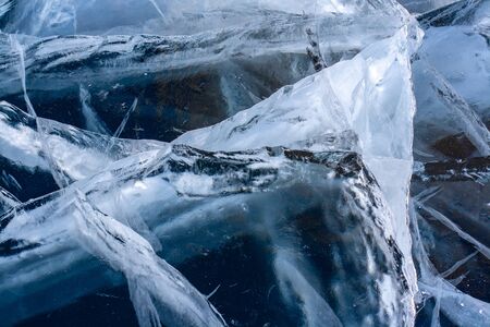 Many natural deep cracks in the ice of Lake Baikal. The structure of ice is visible. Horizontal.