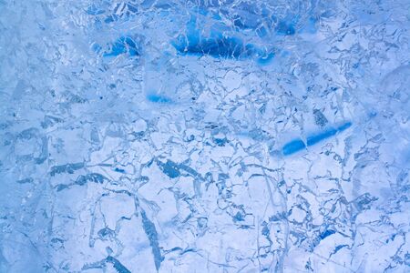 Texture of transparent clear ice with cracks and scratches. Blue Ice with intricate pattern....