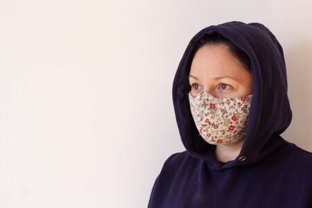 Portrait of a girl with a mask on her face and a hood on her head and copy space. Vietnamese color...