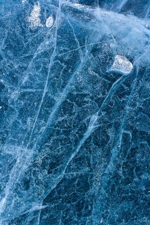 Pattern of lake ice and a small melted ice floe on the background. Air bubbles and cracks. Amazing...