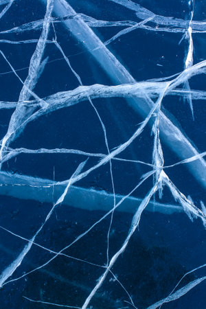 Natural small cracks in blue transparent ice. Beautiful crack pattern. Vertical.の写真素材