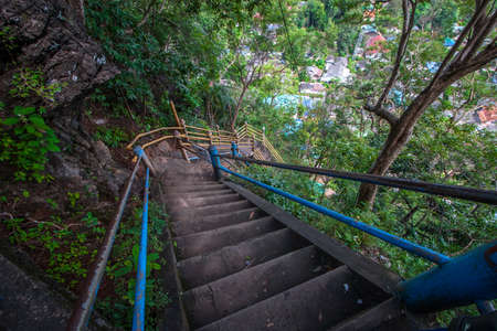 Steep concrete staircase to the rock with iron railings. At the bottom of the rooftops. Lots of...