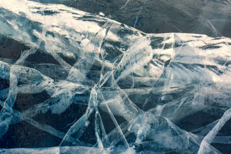 Beautiful cracks in thick ice. The natural texture of ice. Horizontal.