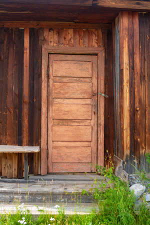 Old Russian door to the house with peeling paint and wooden steps. Vertical image.の写真素材