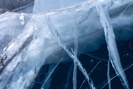 Deep crack in the thick ice of the lake. The natural texture of ice. Horizontal.の写真素材