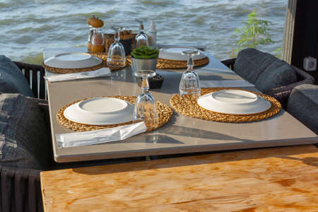 Table in restaurant with overturned plates and mugs is waiting for guests. horizontal photo.の写真素材