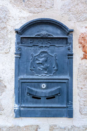 Old mailbox with lion on the coat of arms built into the wall. vertical photo.