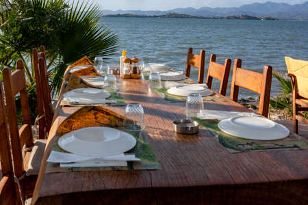 Served table in cafe by the sea with overturned plates and glasses. horizontal photo.