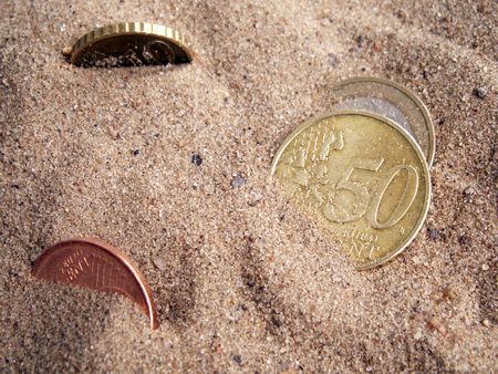 Five european coins on background with sandの写真素材