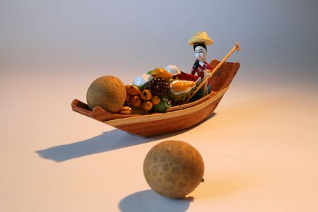 Thai toy as wooden boat with woman and fruitsの写真素材