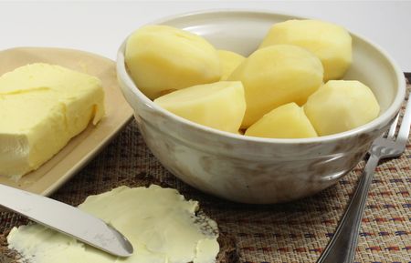 Boiled potatoes in crockery tureen and butter and breadの写真素材