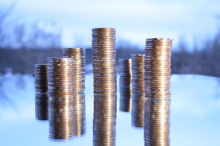 Towers made from coins with reverberation on winter background