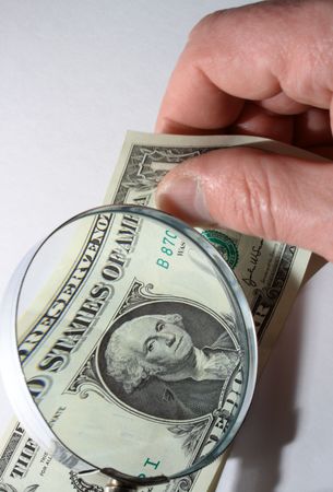 Male hand with one dollar bill and magnifying glass