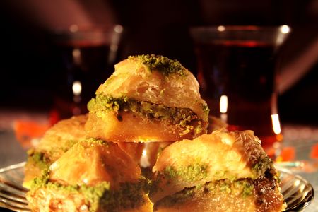 Eastern flacky pastry with honey and pistachio on background with turkish teaの写真素材