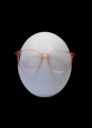 Head made from ostrich egg and spectacles on black backgroundの写真素材
