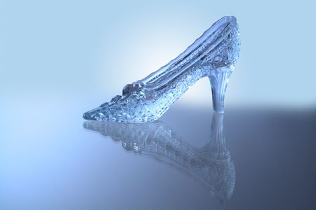 Nice glass slipper with reverberation standing on blue backgroundの写真素材