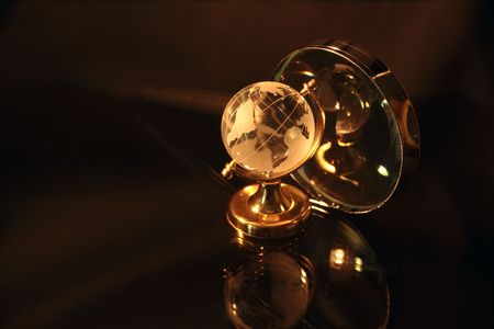 Close-up of magnifier and little glassy earth on dark backgroundの写真素材