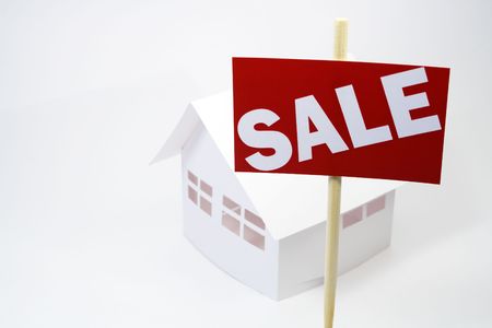 Tablet with sale inscription standing near papery house on white backgroundの写真素材