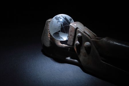 Rusty spanner with little glassy globe on dark backgroundの写真素材