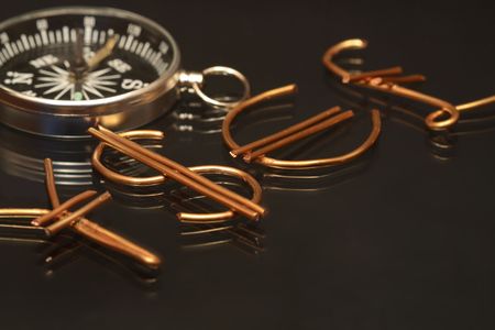 World money signs made from wire and compass on darkの写真素材