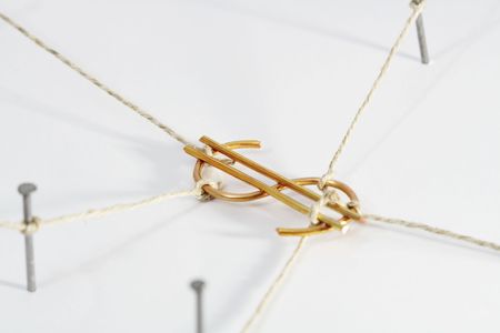 Dollar sign constrained with ropes and nails on white background