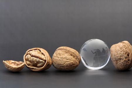 Three walnuts and glassy globe on gray backgroundの写真素材