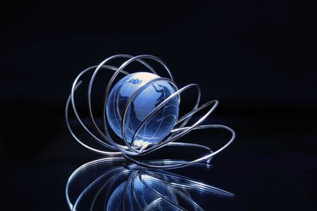 Glassy globe inside tangle made from wire on dark backgroundの写真素材