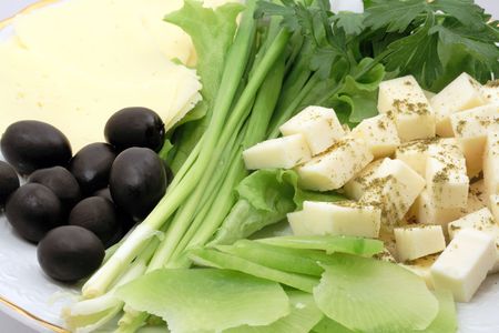 Close-up of cheese and vegetables with olivesの写真素材