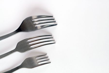 Three forks of different sizes lying on white backgroundの写真素材