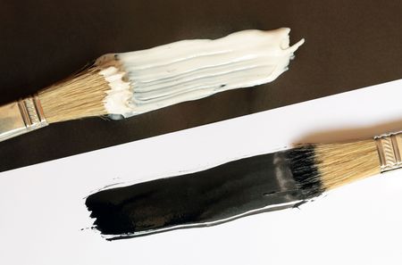 Background of two brushes with black and white paintsの写真素材