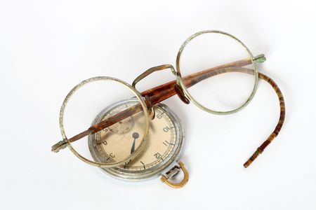 Vintage spectacles and watch lying on white backgroundの写真素材