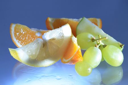 Various fruits lying on glassy blue backgroundの写真素材