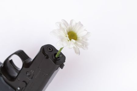 Black modern automatic pistol with flower isolated on white backgroundの写真素材