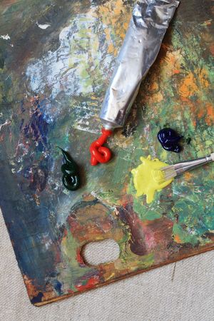 Brush and oil paints on background with colorful wooden palette の写真素材