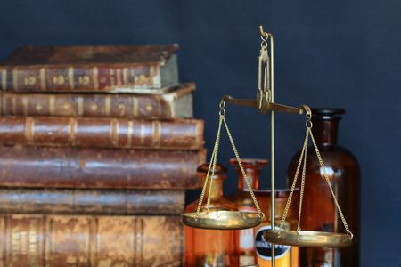 Vintage weight scale on background with old books and vialsの写真素材