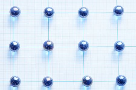 Background made from blue glass balls lying on squared paperの写真素材