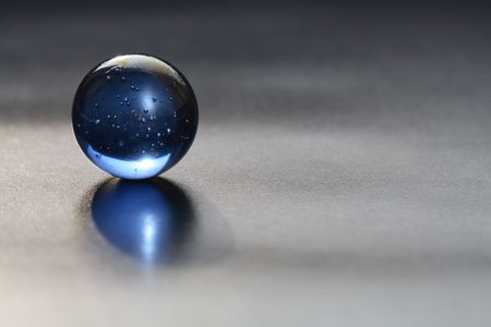 A lone glass ball isolated on dark backgroundの写真素材