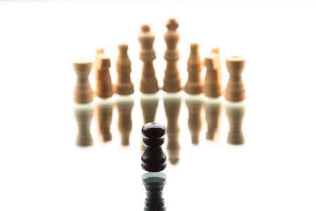 Chess game composition. Black single pawn against white chess armyの写真素材