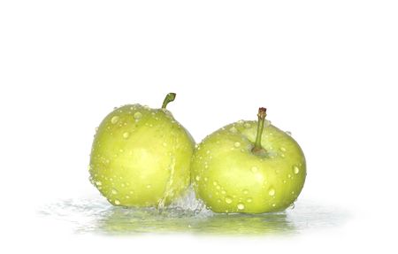 Two fresh green apples under water drops の写真素材