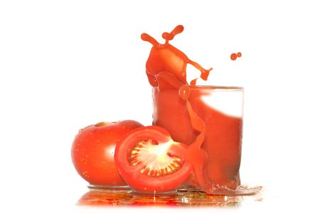 Two tomatoes near glass of splashing tomato juice isolated on white backgroundの写真素材