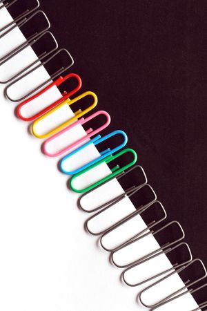 Close-up of multi-colored paper clips on a white and black backgroundの写真素材