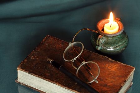 Vintage still life with candle and old things: book, spectacles,penの写真素材