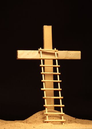 Ladder standing near wooden cross on dark backgroundの写真素材