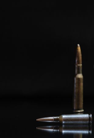 Two high power rifle cartridges on a dark background with copy spaceの写真素材