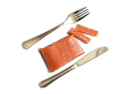 Fork and knife near fresh salmon steak isolated on white background の写真素材