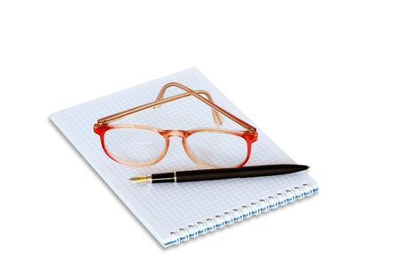Spectacles and fountain pen lying on spiral notebook. Isolated on white の写真素材