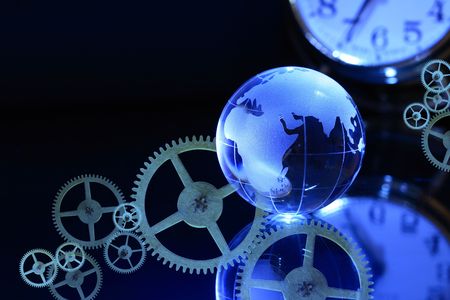 Glass globe on dark background with clock dial and gearsの写真素材